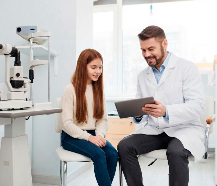 Especialista en oftalmología realizando una valoración visual de estrabismo a una niña en Clínica Láser de Ojos Medellín.